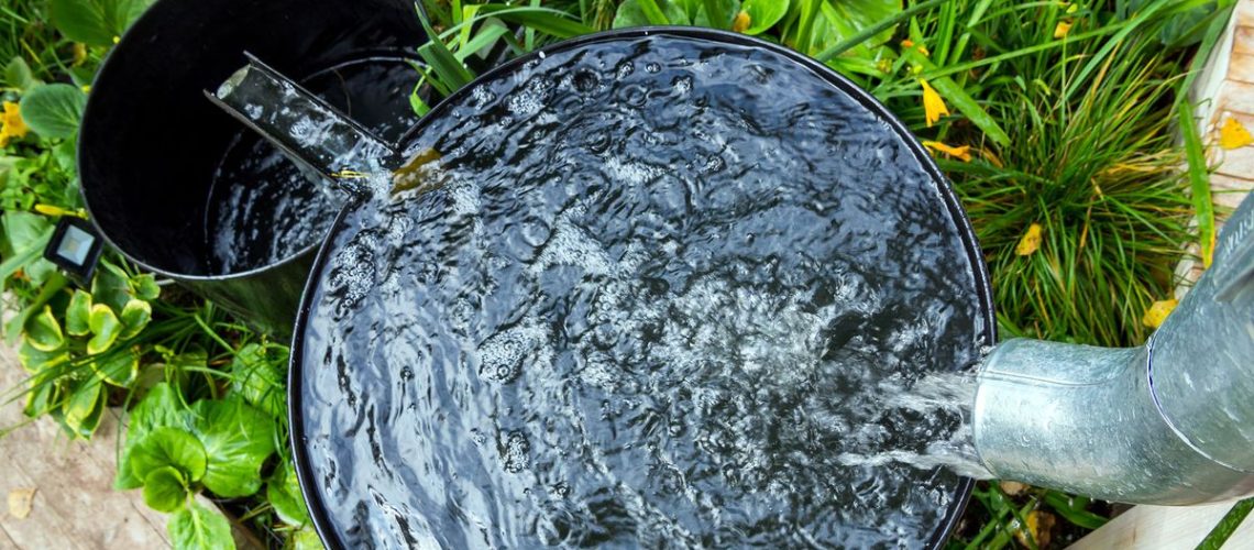 Rainwater butt in garden running off to second barrel