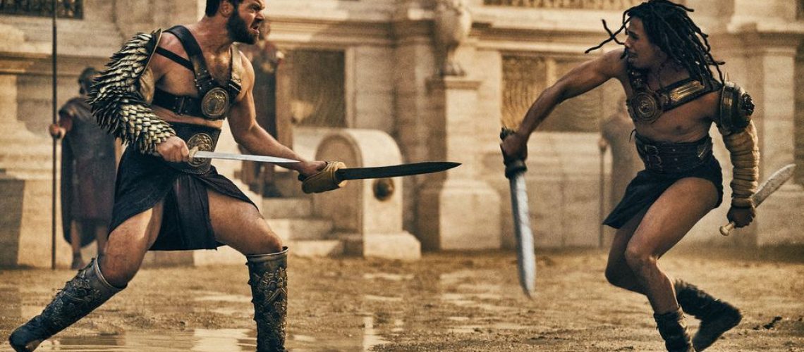 Viggo (Jóhannes Haukur Jóhannesson) and Kwame (Moe Hashim) decked out in gladiator gear as they face off in the arena in