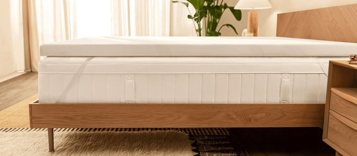 The Tempur-Pedic Tempur Adapt Mattress Topper on top of a bed in a warm, sunny bedroom