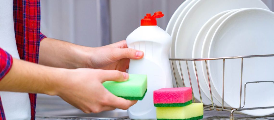 Dish soap next to three sponges