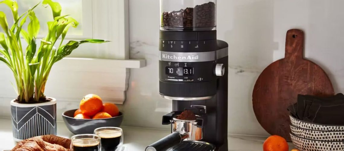 The KitchenAid Burr Coffee Grinder being used to grind espresso in a kitchen