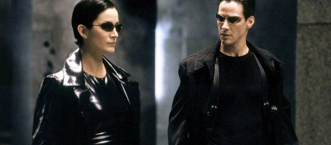 Trinity (Carrie Ann Moss) and Neo (Keanu Reeves) standing next to each other in