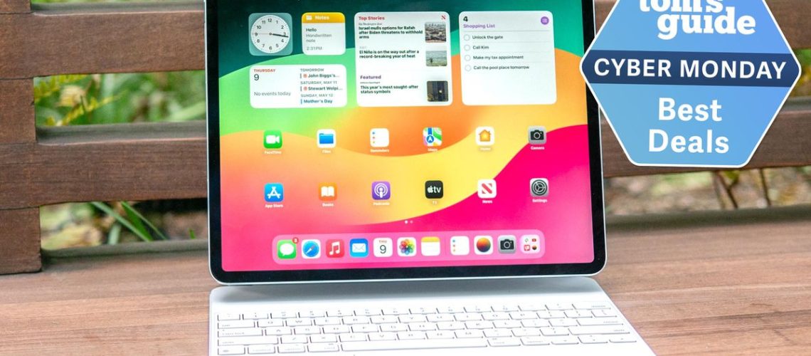 The iPad Air M2 on a wooden surface, the home screen is showing and there is a keyboard attached. A Tom