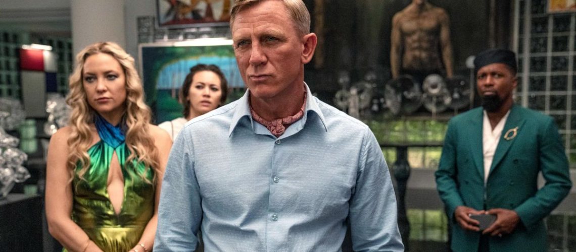 (L - R) Kate Hudson as Birdie, Jessica Henwick as Peg, Daniel Craig as Detective Benoit Blanc, and Leslie Odom Jr. as Lionel in 'Glass Onion: A Knives Out Mystery'