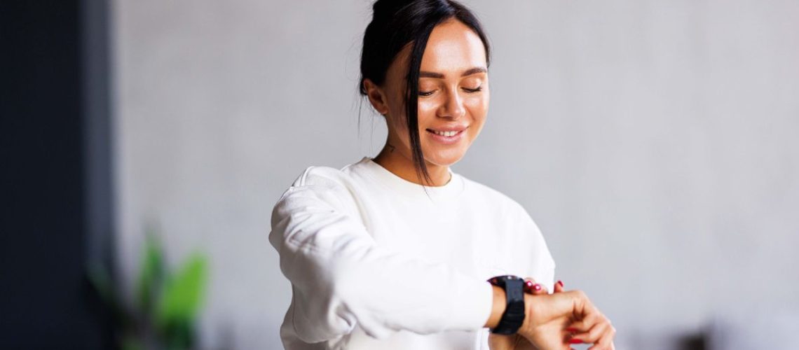 a photo of a woman looking at her fitness tracker