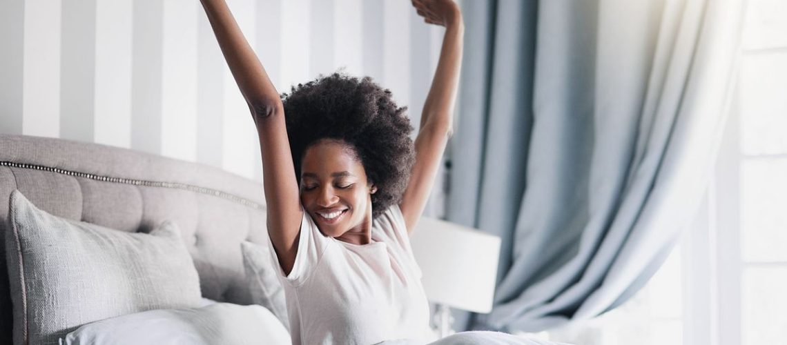 woman waking up, stretching and smiling
