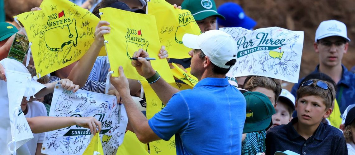 Rory McIlroy of Northern Ireland signs autographs for young patrons after competing in the par 3 competition prior to the Masters Tournament at Augusta National Golf Club in Augusta, Georgia. (Photo by David Cannon/Getty Images)