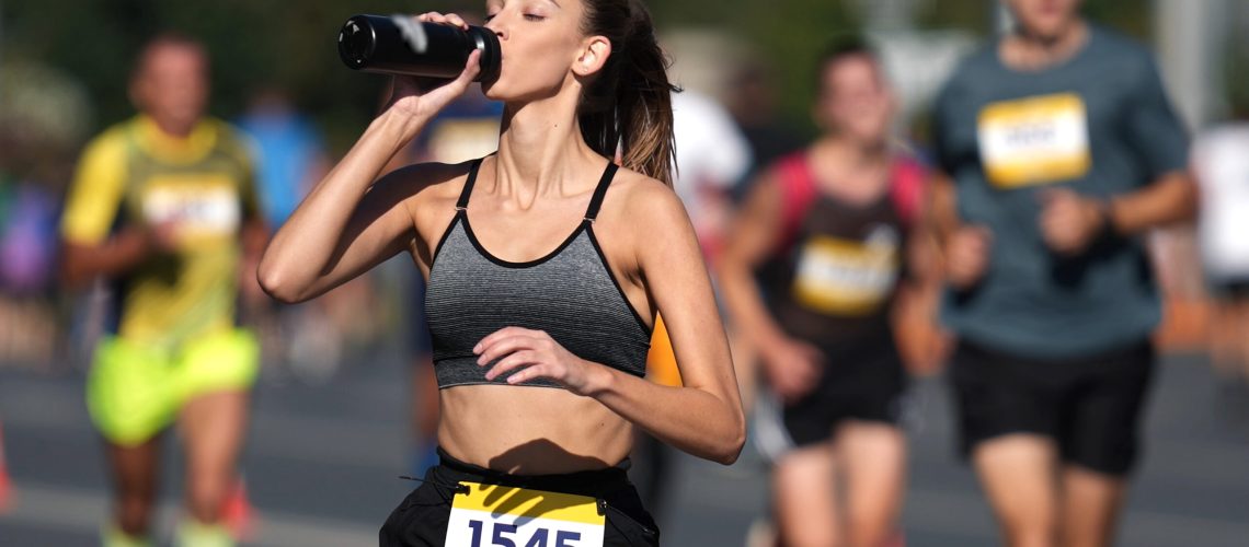 a female runner drinking water during a race