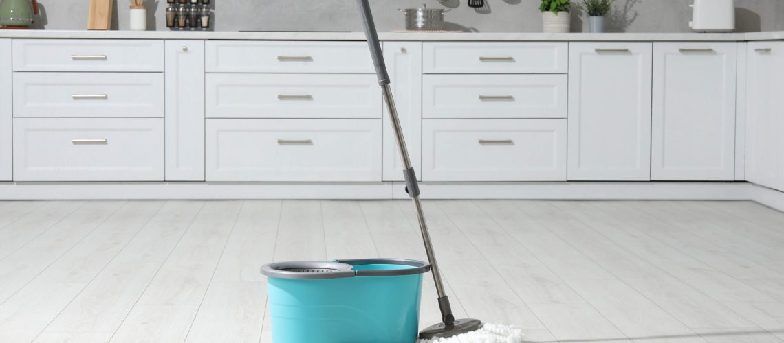 Blue bucket and mop on kitchen floor