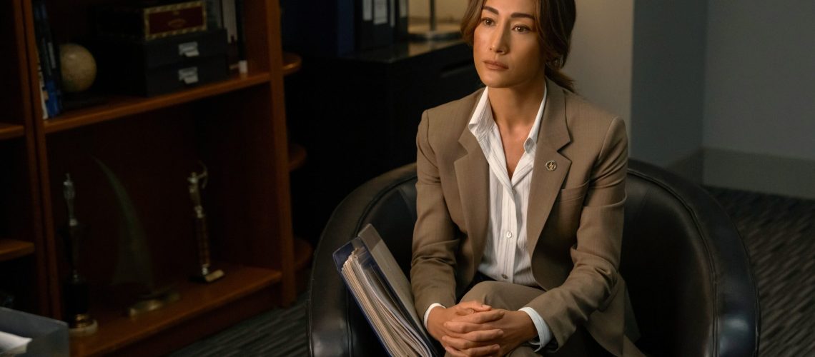 Renée Ballard (Maggie Q) sits cross-legged in an armchair in an office in a scene from Prime Video