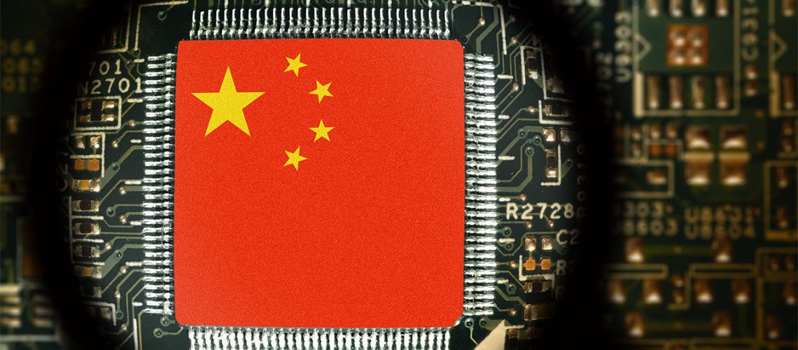 Chinese flag on a computer board, viewed through a magnifying glass