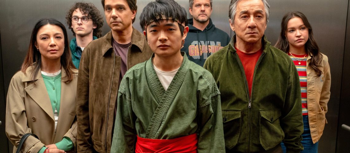The "Karate Kid: Legends" main ensemble standing together in an elevator in a scene from the movie. L-R: Ming Na Wen, Wyatt Oleff, Ralph Macchio, Ben Wang, Joshua Jackson, Jackie Chan and Sadie Stanley