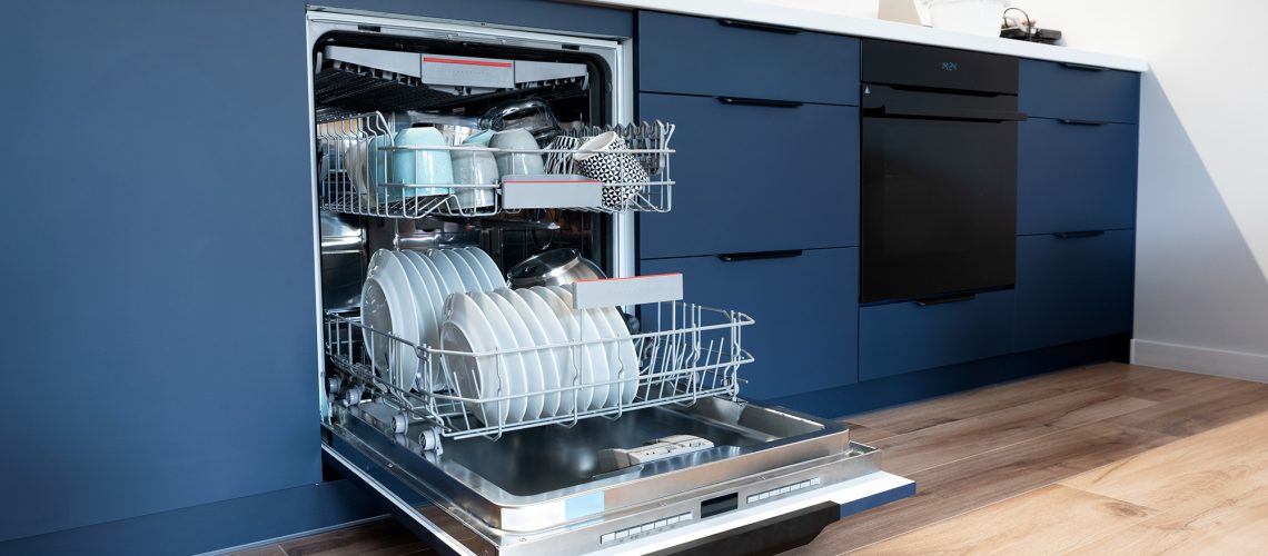 Open dishwasher door in kitchen showing a loaded appliance