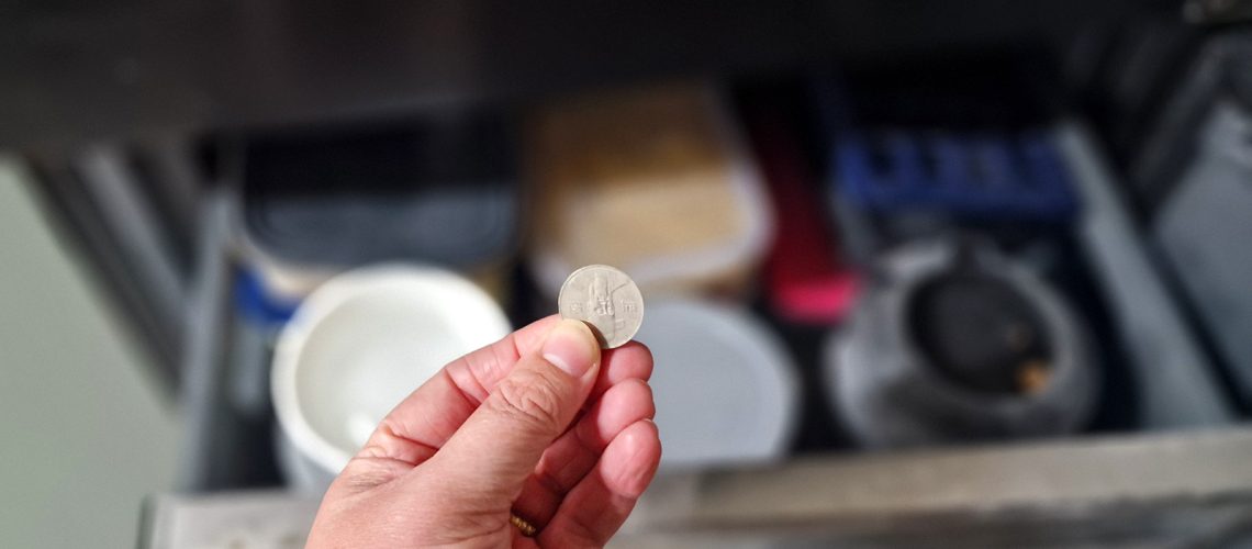 Holding a coin in front of a freezer