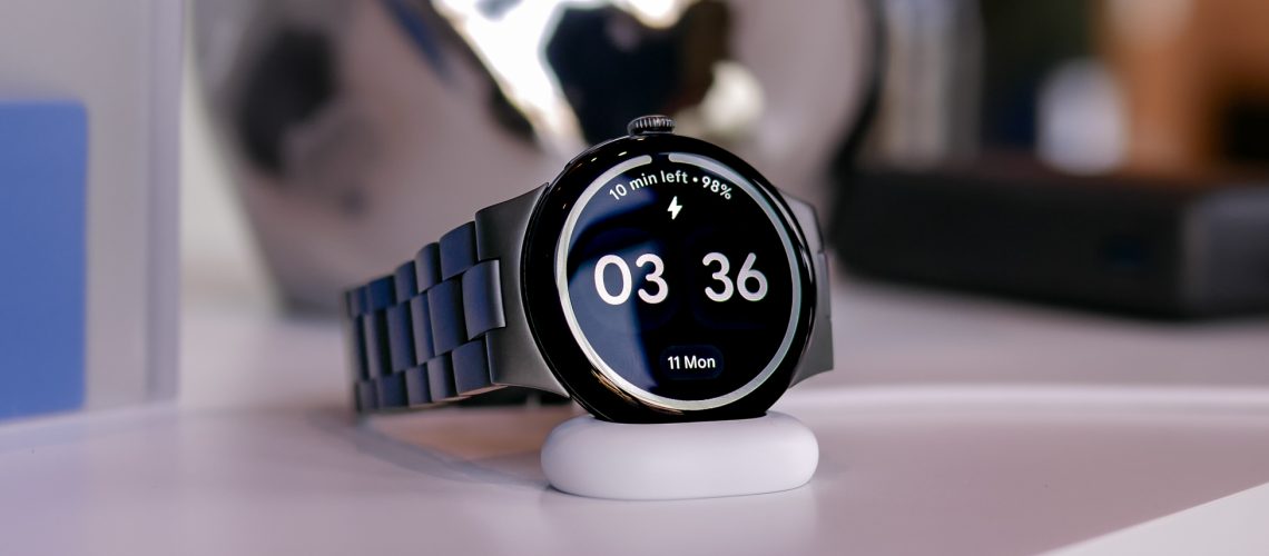 Close-up shot of the Google Pixel Watch 4 in black shown charging on its side
