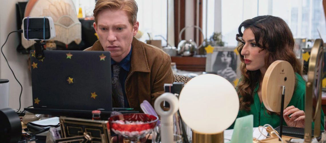 L-R: Ned (Domhnall Gleeson) and Esmeralda (Sabrina Impacciatore) sitting at a computer desk in a scene from "The Paper"