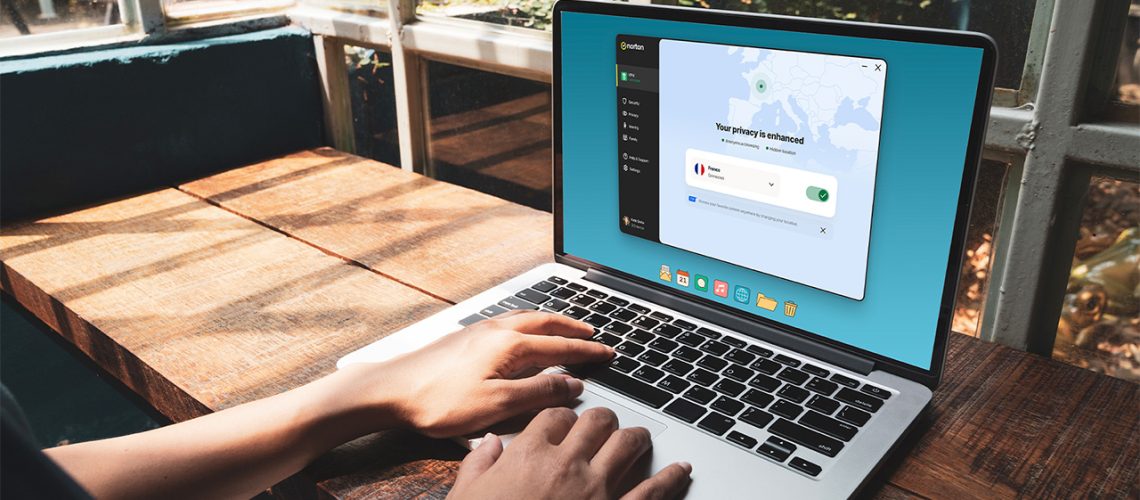 A person works on a laptop that displays Norton VPN software on the screen.