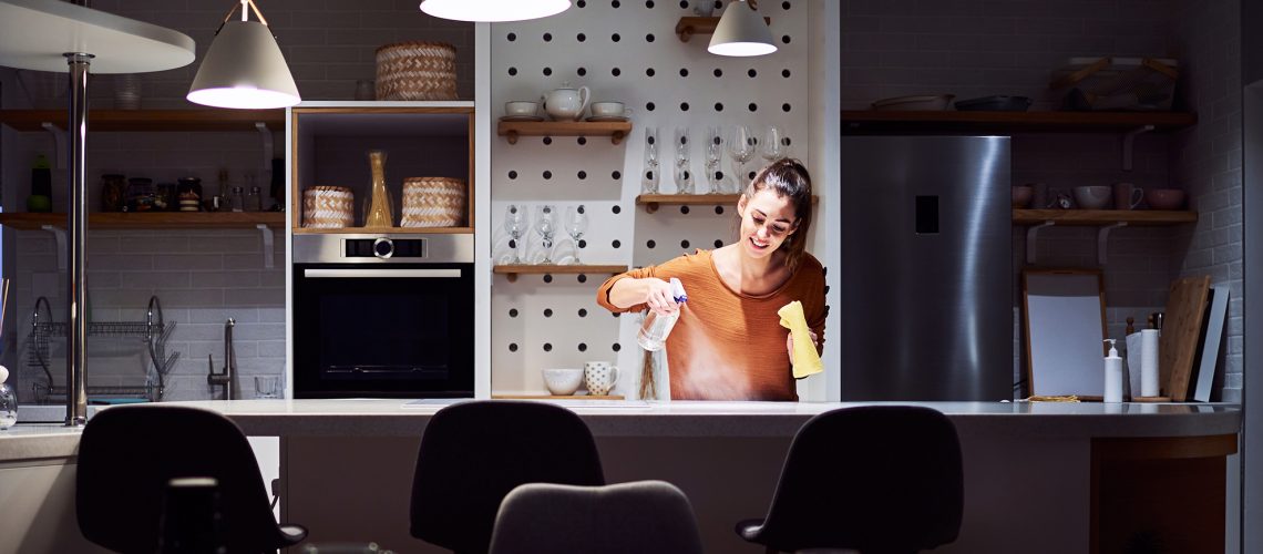 woman cleaning kitchen at night