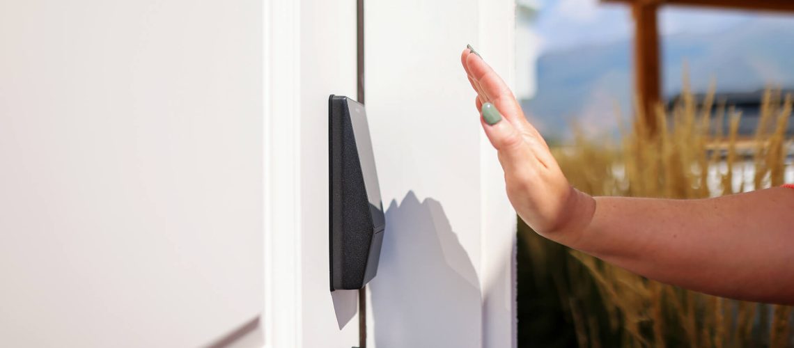 A hand reaching towards a front door that has Wyze's Palm Lock installed