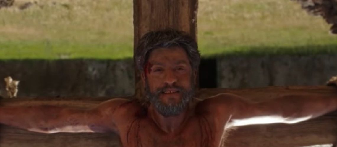 Saint Peter smiling gently while enduring crucifixion upside-down by the Romans, in a screenshot from docuseries "The Saints" season 2.