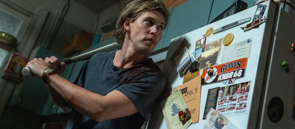 Hank (Austin Butler) readies a baseball bat in his kitchen inside his apartment in a scene from "Caught Stealing"