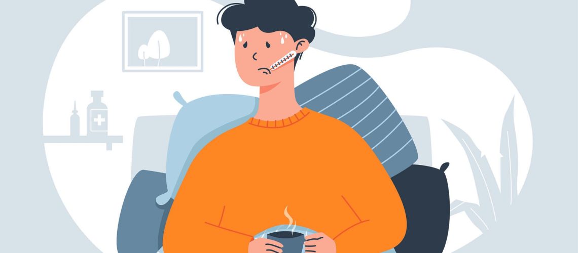 An illustration of a person wearing a yellow sweater in bed with the cold or flu, against a greay background. The person is holding a warm drink, lying propped up on pillows, with a thermometer in their mouth