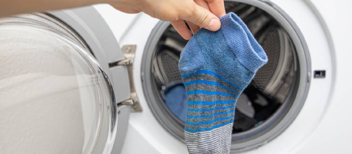 Socks held up against a washing machine