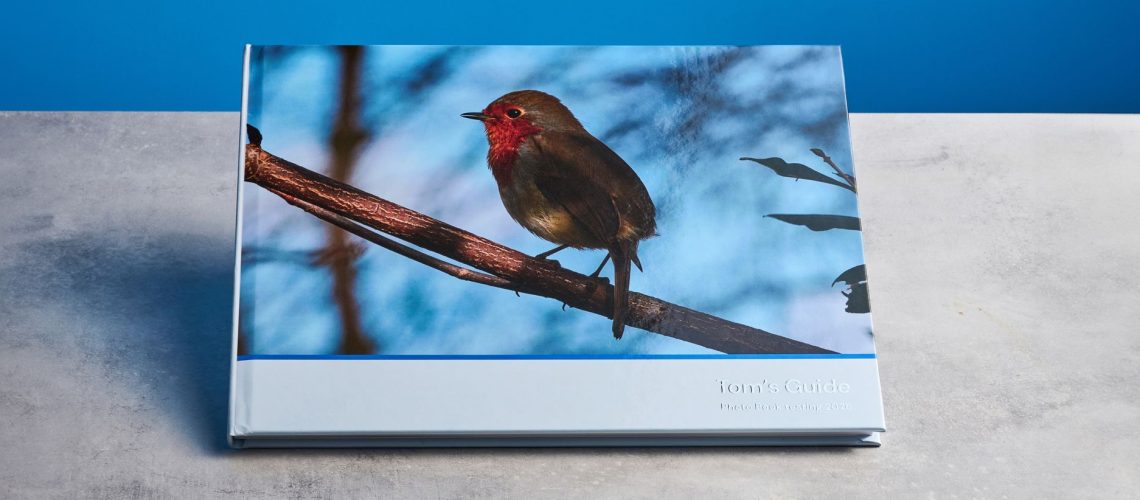 Popsa photo book photographed in front of a blue background