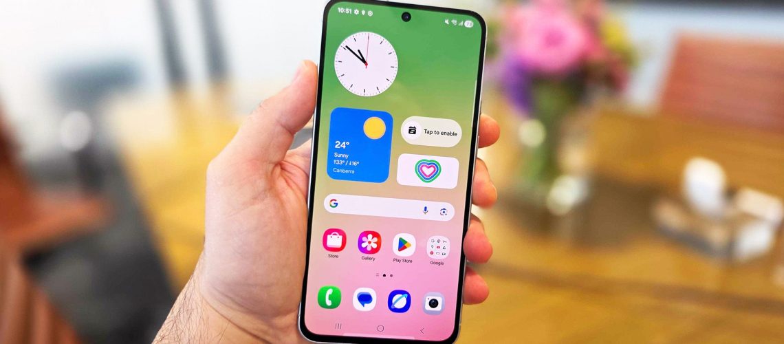 In-hand image of the Samsung Galaxy A56 handset with view of its home screen.