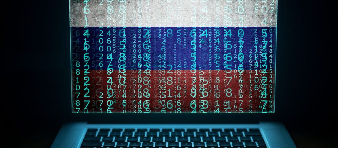 Computer with binary computer code and Russian flag on the screen