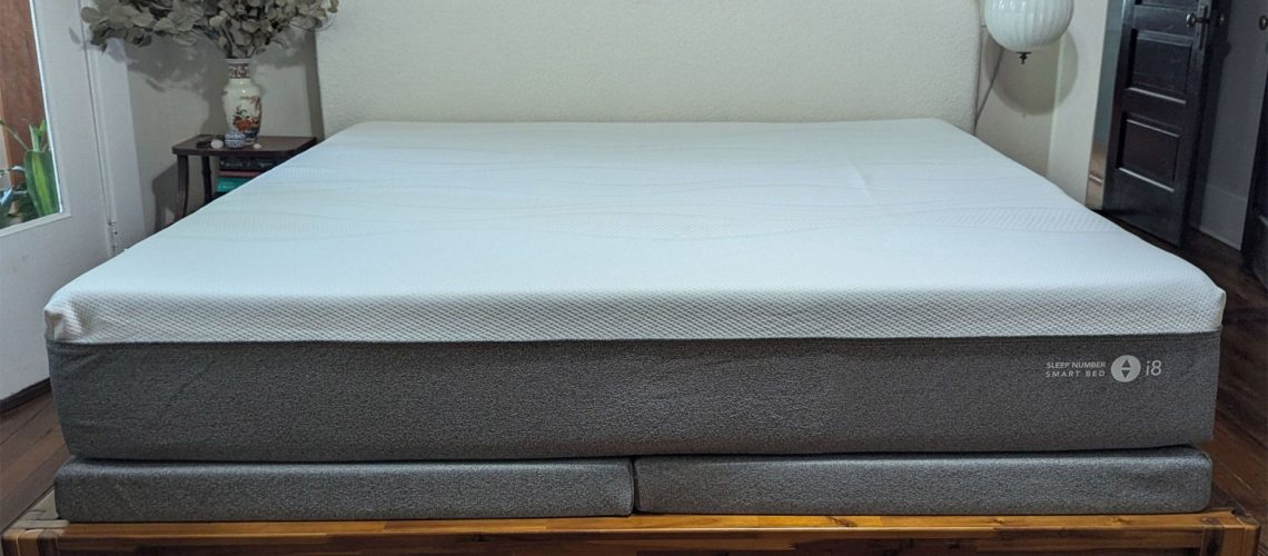 Grey and white Sleep Number i8 smart mattress on wooden bedframe