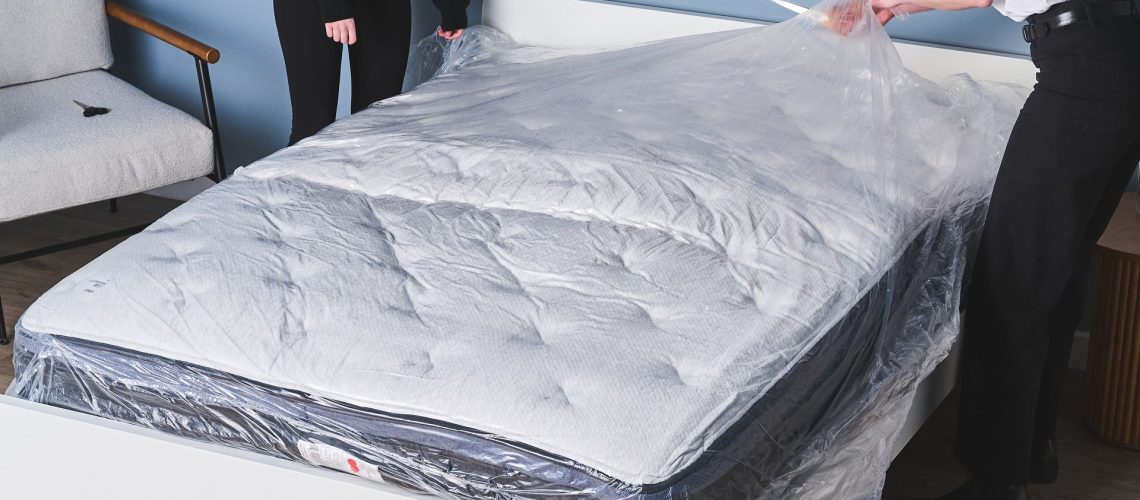 Two mattress testers unboxing a memory foam mattress to test its off-gassing