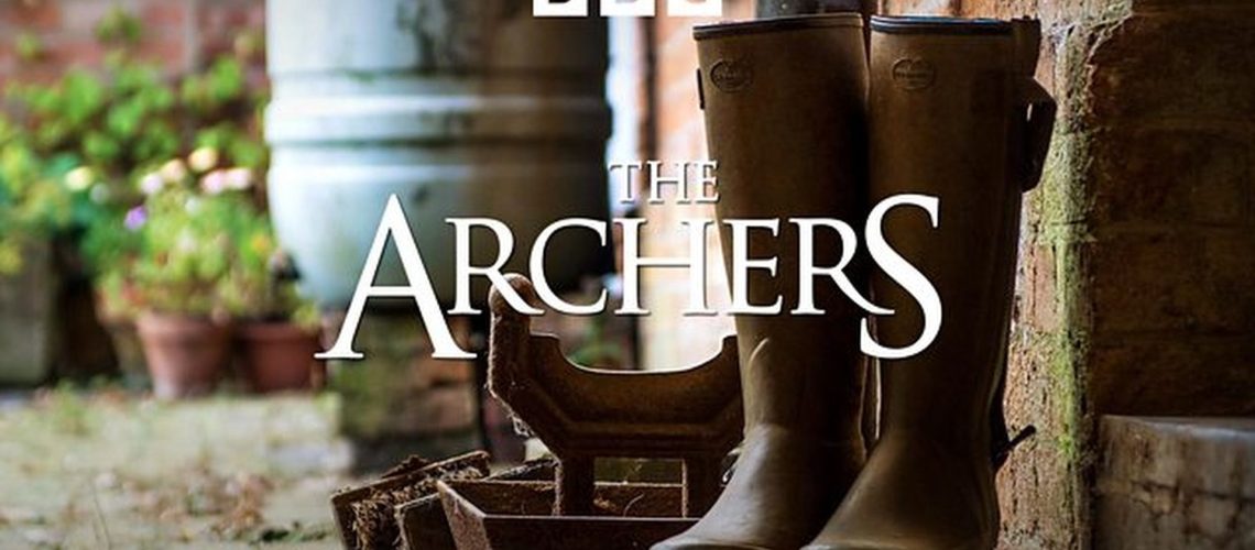 Promotional title card for "The Archers" featuring the title displayed over a pair of wellington boots in a rural English setting