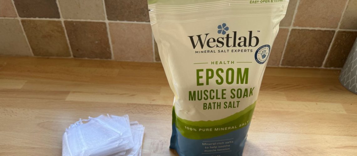 A bag of epsom salts and a pile of small net bags lay on a countertop