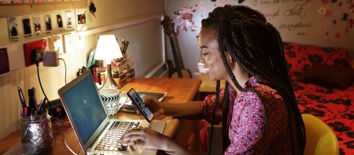 Student working on laptop in dorm room