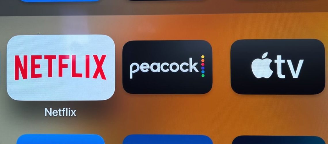 Netflix, Peacock and Apple TV Plus logos on a screen