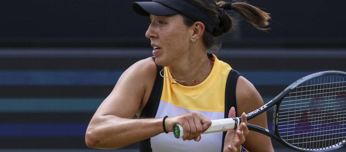 Jessica Pegula plays a shot in a yellow, white and black vest