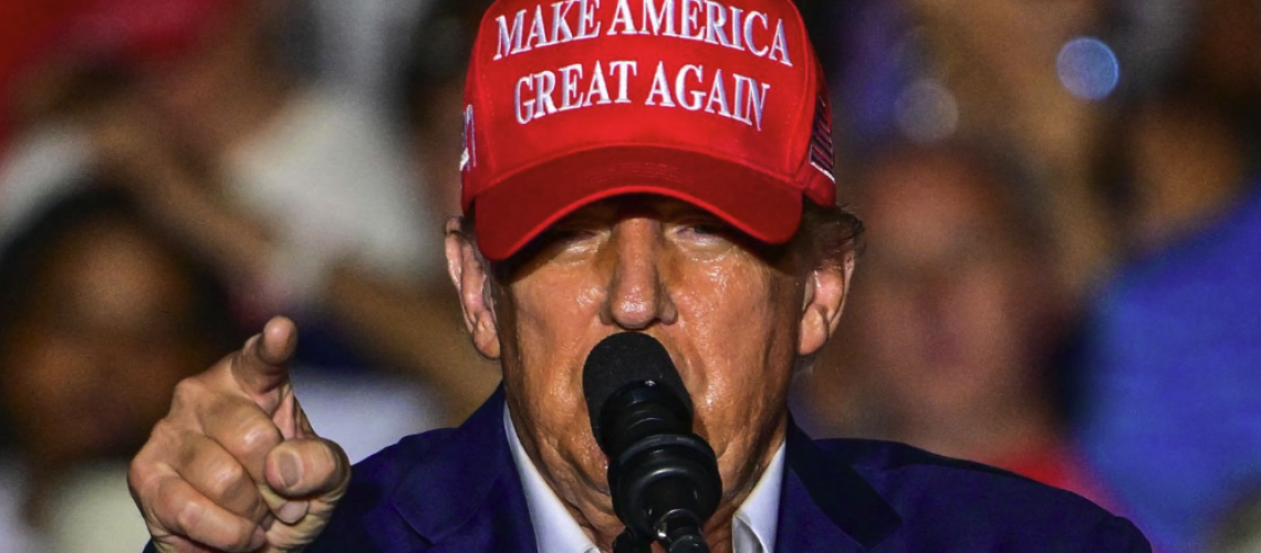 Former US President and Republican presidential candidate Donald Trump, wearing a red and white MAGA cap, gestures as he speaks ahead of his RNC 2024 Republican National Convention speech in Milwaukee
