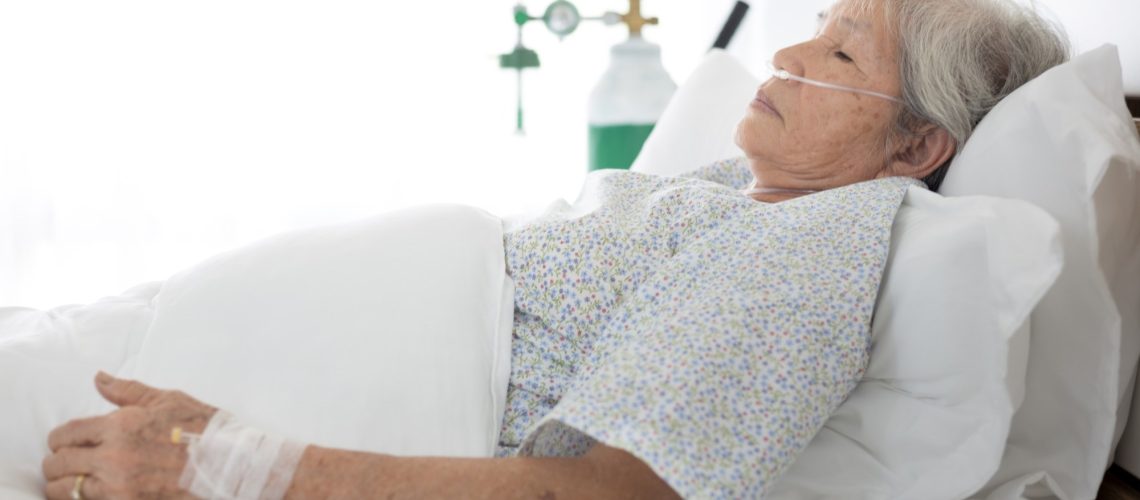 Elderly patient wear oxygen cannula in hospital bed