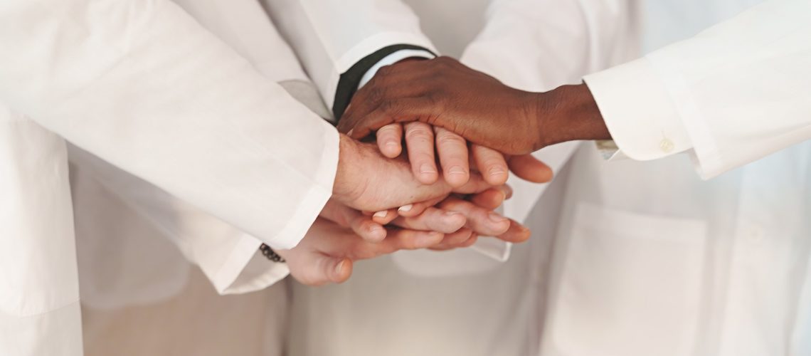 Close-Up of United Hands in Lab Coats, Faces not Visible