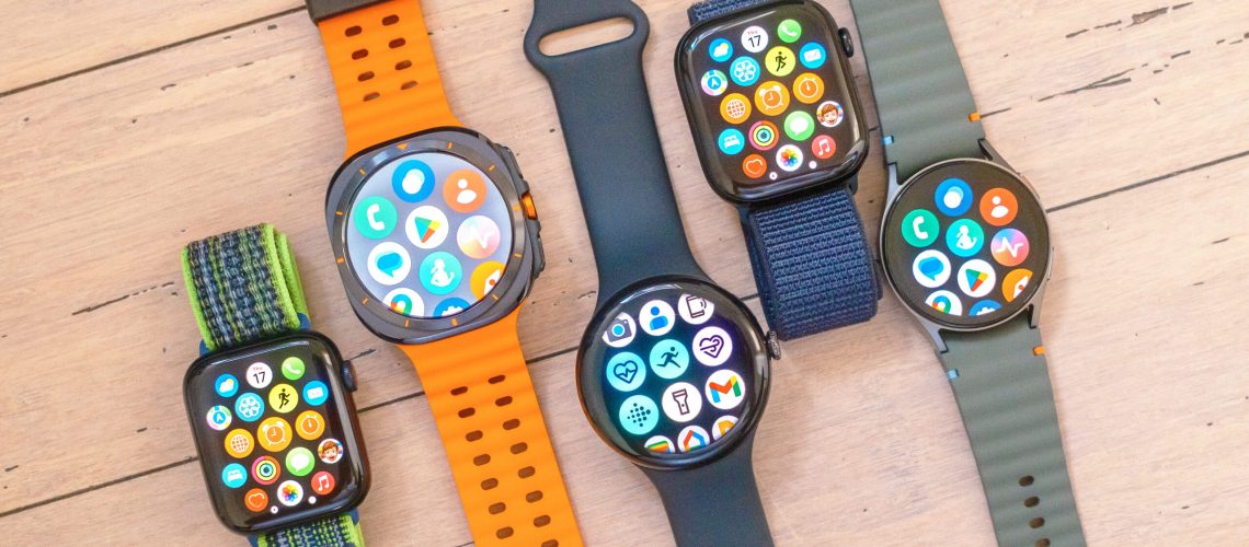 A close-up of five smartwatch on a wooded surface including the Apple Watch SE, Samsung Galaxy Watch Ultra, Google Pixel Watch 3 XL, Apple Watch 10 and Samsung Galaxy Watch 7