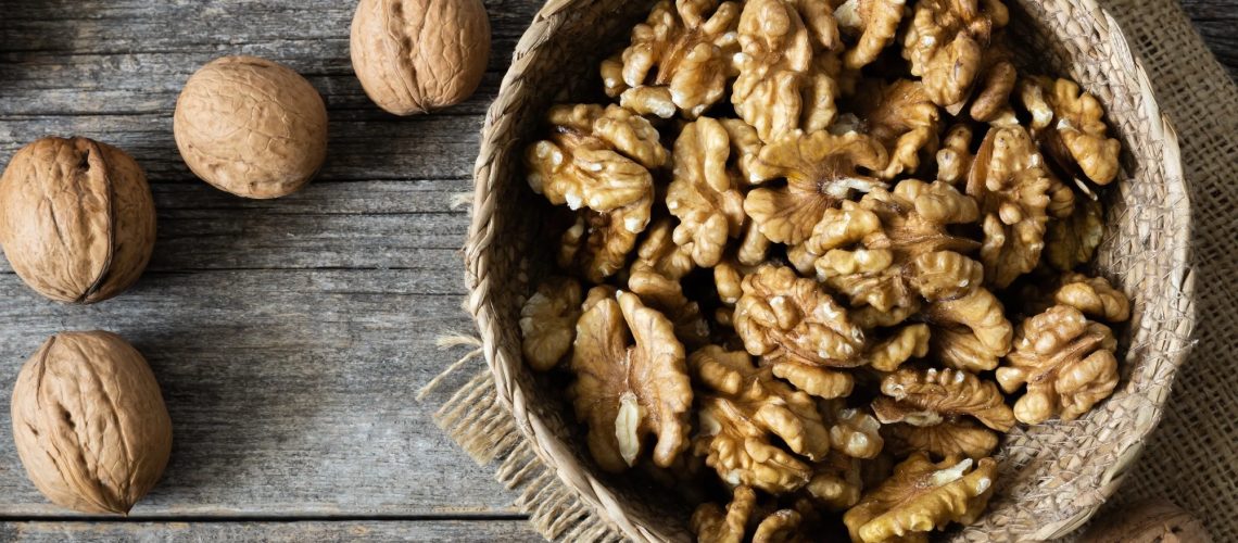 Bowl of walnuts next to unshelled walnuts