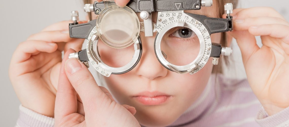 young girl smiling while undergoing eye test