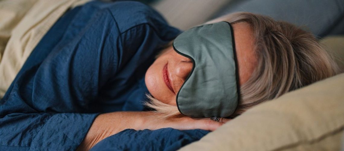 A woman sleeping on her side wearing an eye mask