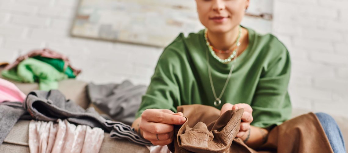 Woman sitting on a sofa decluttering clothing
