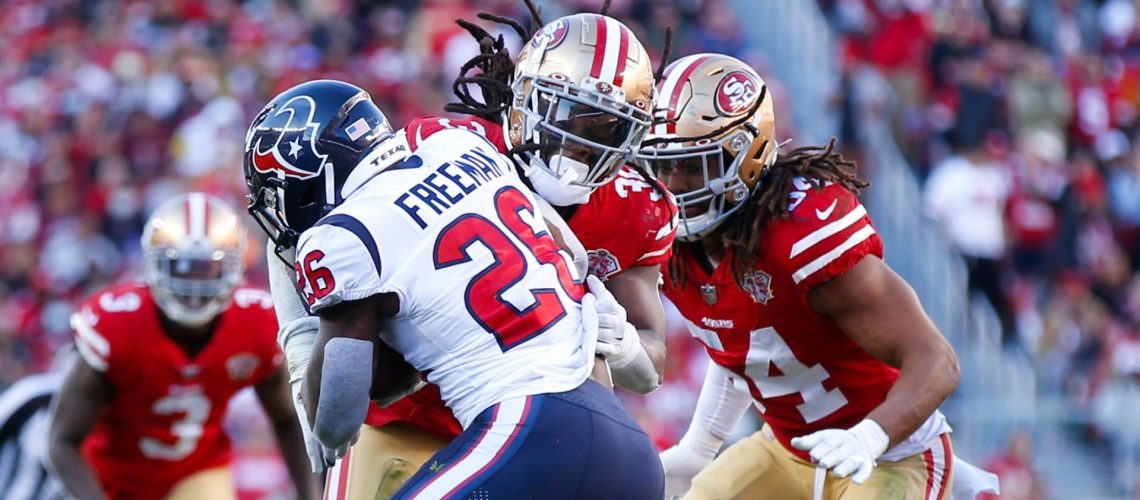 Marcell Harris and Fred Warner of the San Francisco 49ers tackle Royce Freeman of the Houston Texans during an NFL game on January 2, 2022