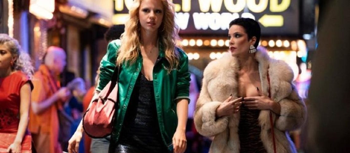 Maxine Minx (Mia Goth) and her friend Tabby Martin (Halsey) walk through a neon-drenched Los Angeles in Ti West horror film "MaXXXine"