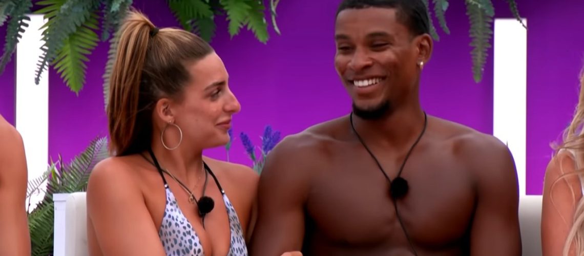 One of the villa's favorite couples, Vegas pool girl Toni sits arm-in-arm with model and dancer Cach Mercer during a game of Couple Goals around the firepit in a screenshot from "Love Island U.K" season 12.