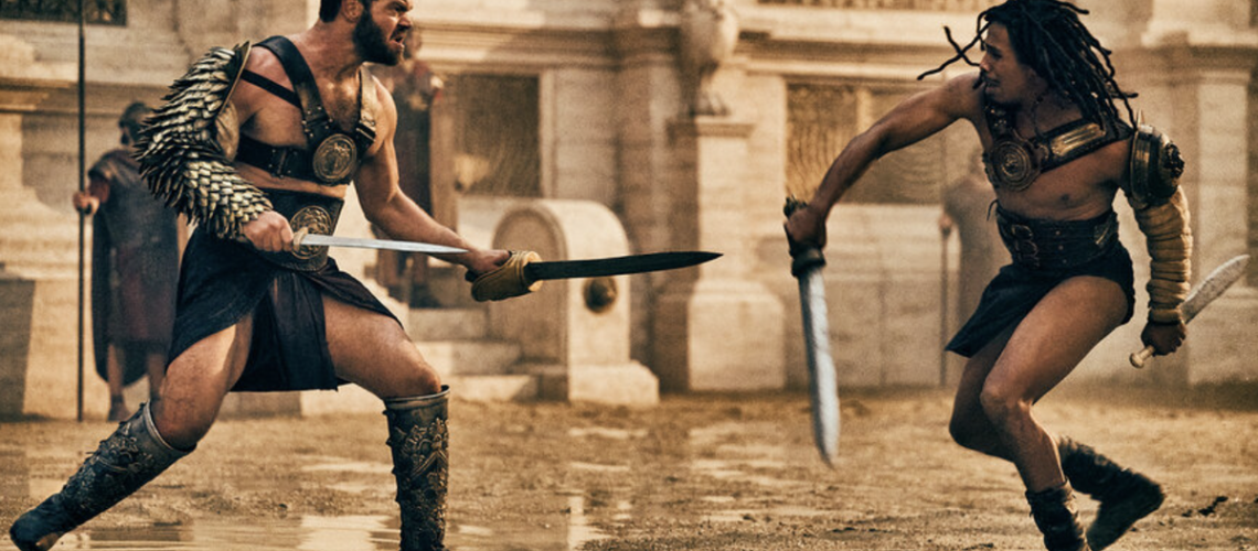Gladiators Viggo (Johannes Haukur Johannesson) and Kwame (Moe Hashim) fighting with swords in the Colosseum in Those About to Die