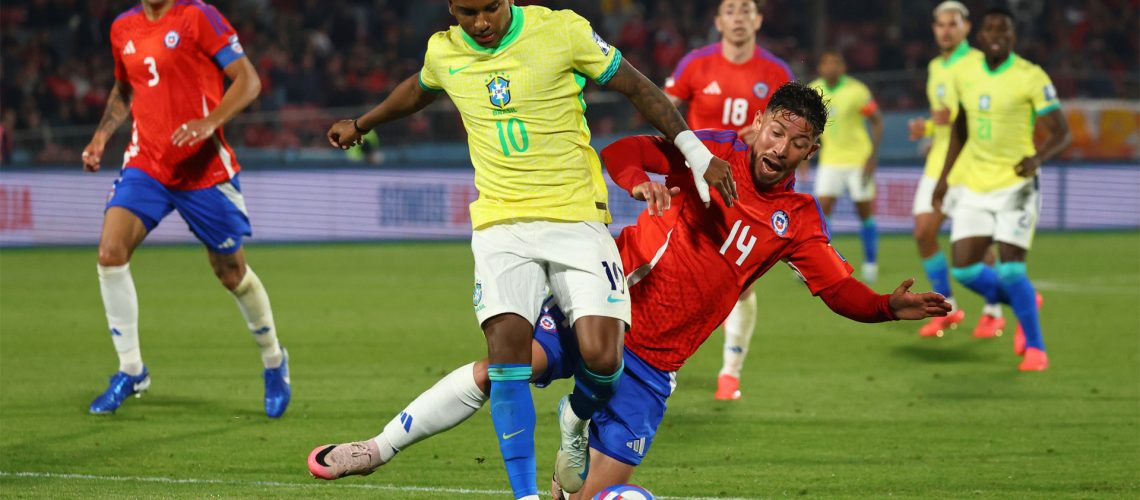 Brazil's Rodrygo shields the ball from a challenge from Chile's Felipe Loyola during an October 2024 World Cup qualifier.